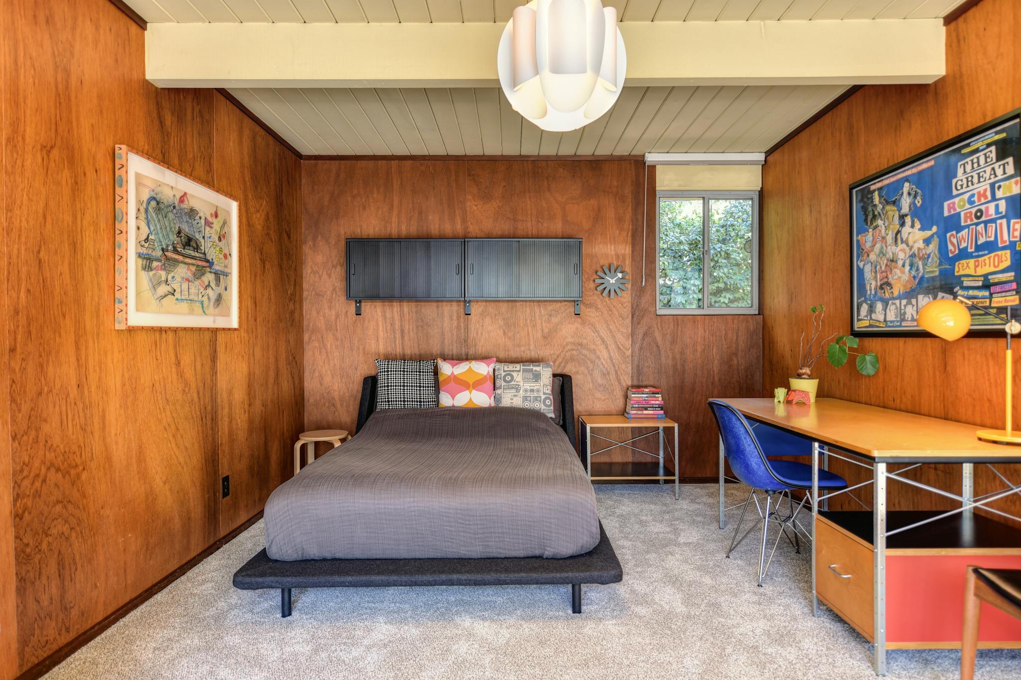 Beautiful mid-century modern bedroom with wooden walls and stylish decor.